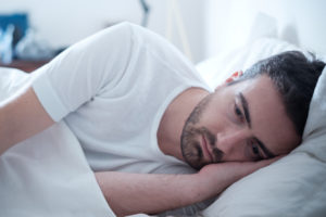 Man laying in bed depressed